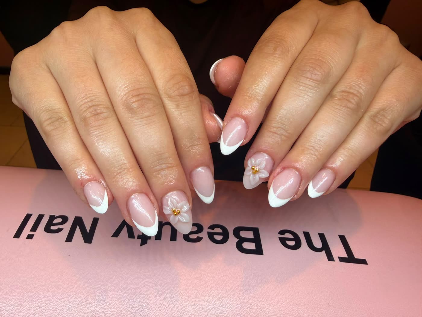 Amandelvormige french manicure met een witte 3D bloem en gouden hart