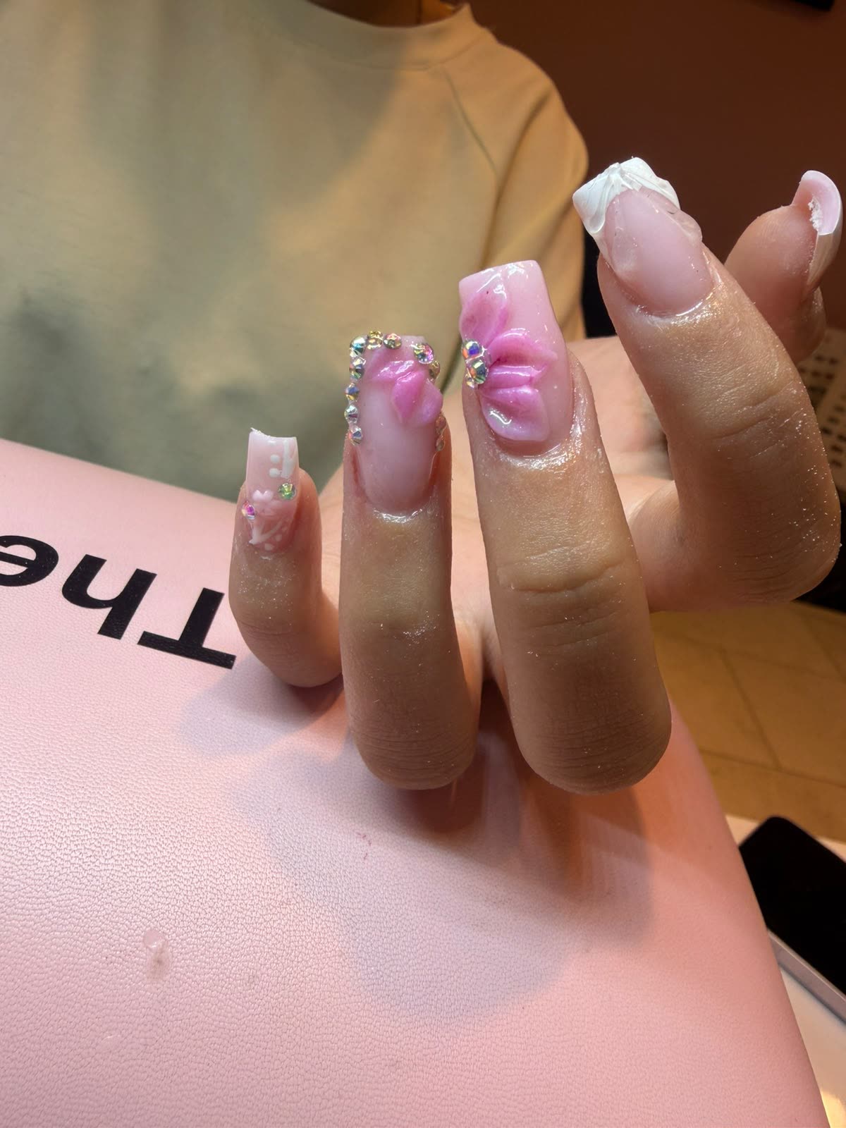 Lichtroze nagels met 3D bloemen en een rij strass