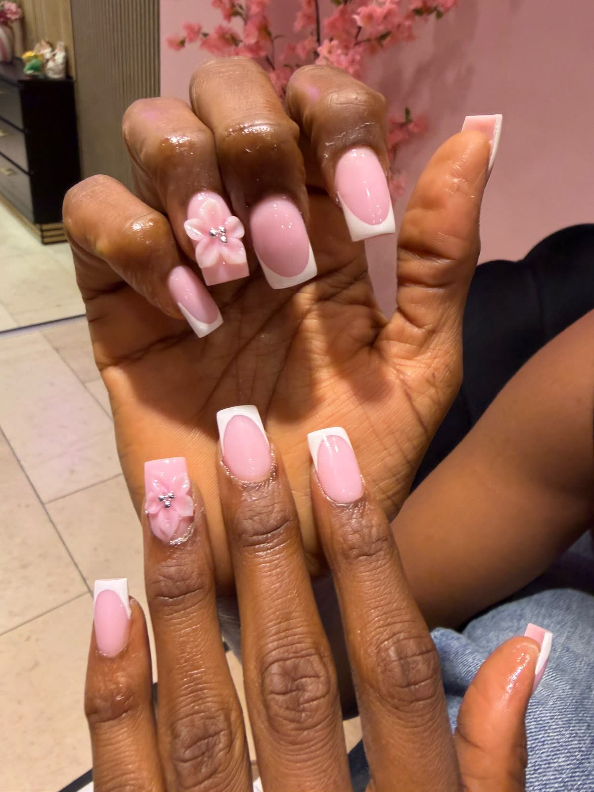 Vierkante french manicure met een roze 3D bloem in een roze salon